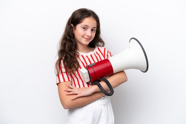 Little girl isolated on white background holding a megaphone and smiling