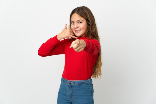 Little girl over isolated white background making phone gesture and pointing front