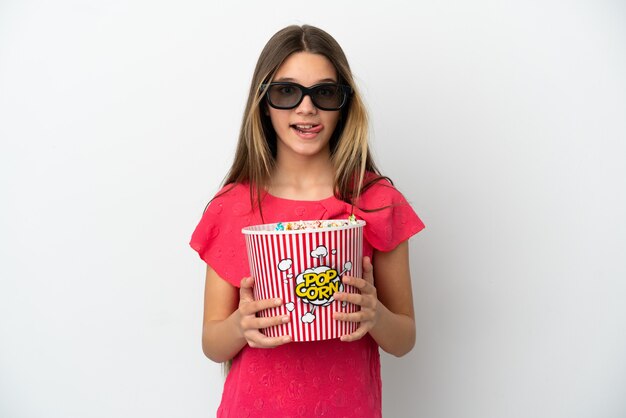 Little girl over isolated white background with 3d glasses and holding a big bucket of popcorns