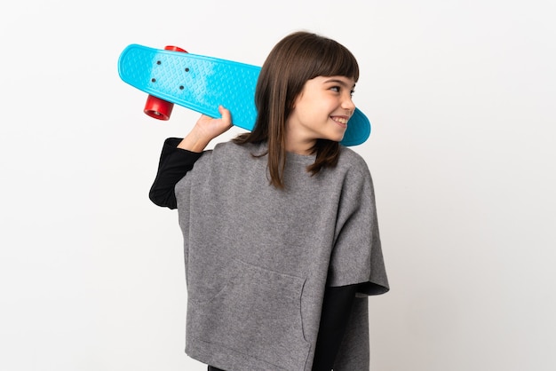 Little girl isolated on white background with a skate