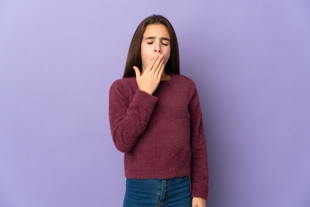 Little girl isolated yawning and covering wide open mouth with hand