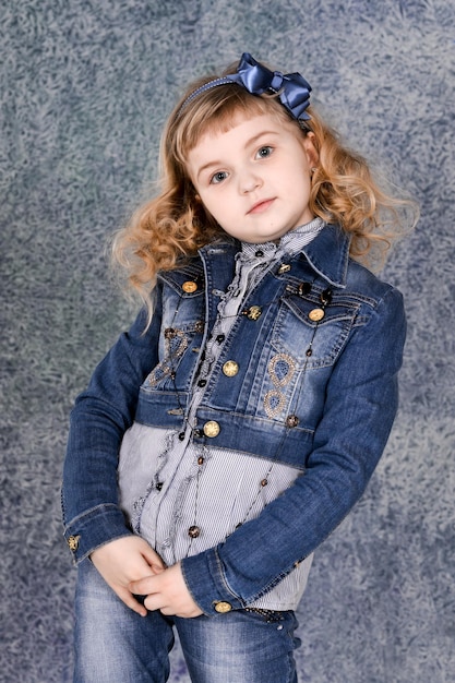 Bambina in giacca di jeans in posa