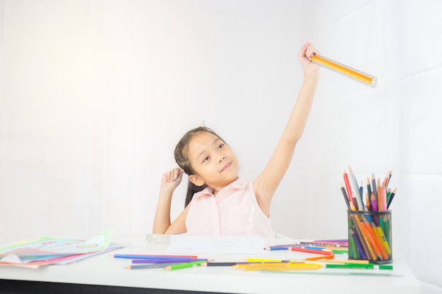Little girl kid drawing picture with colorful pencils, ruler and pencil in hand