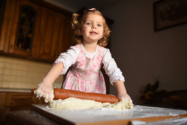 Little girl kneading dough