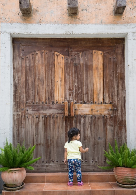 La bambina batte sulla porta chiusa di legno