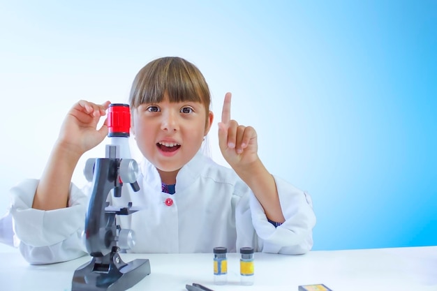 A little girl in a lab coat raises a finger up The concept of learning and scientific achievements