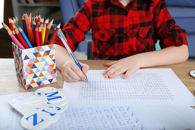 Little girl learning to draw at the table