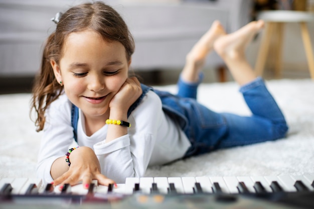 Little girl learning how to play the piano