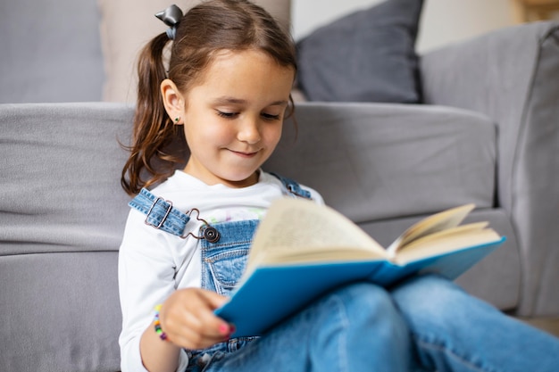 Photo little girl learning how to read from a book