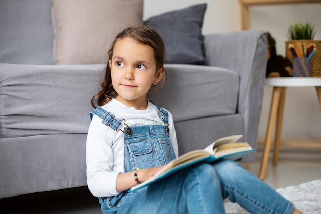 Foto bambina che impara a leggere da un libro