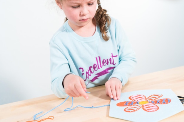 Little girl learning how to sew with sewing craft kit for kids