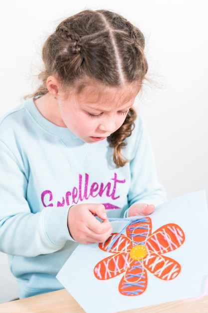 Little girl learning how to sew with sewing craft kit for kids