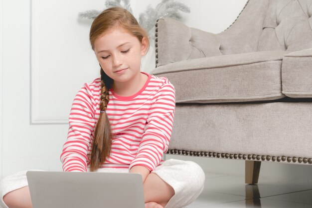 Little girl learning with computer at home.