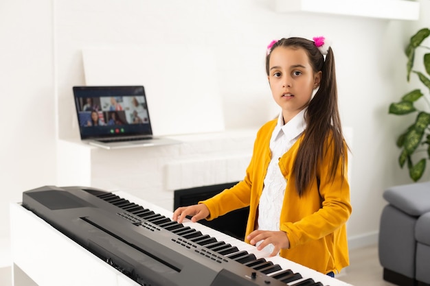 a little girl learns to play the synthesizer. learning to play musical instruments.