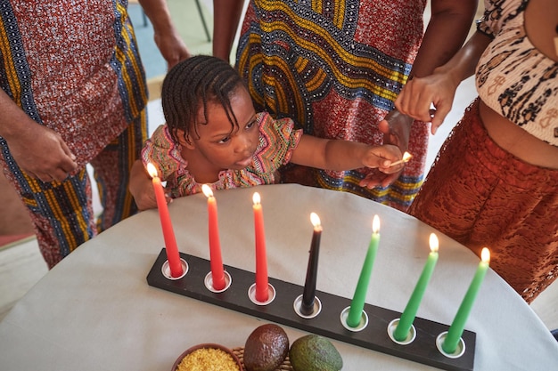 Photo little girl lighting candles for holiday