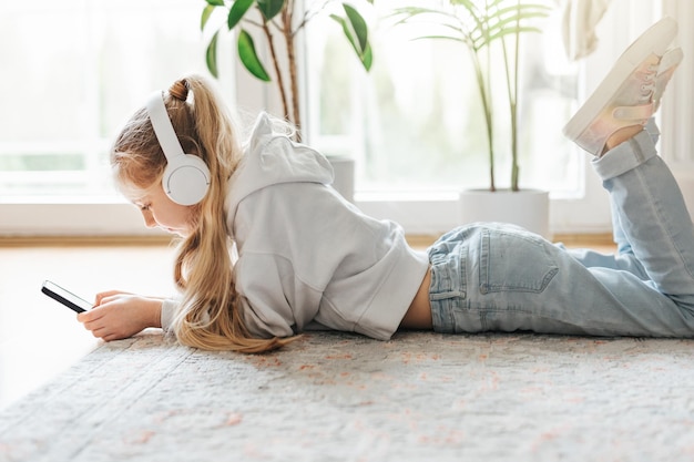 Little girl listening music lying on the floor