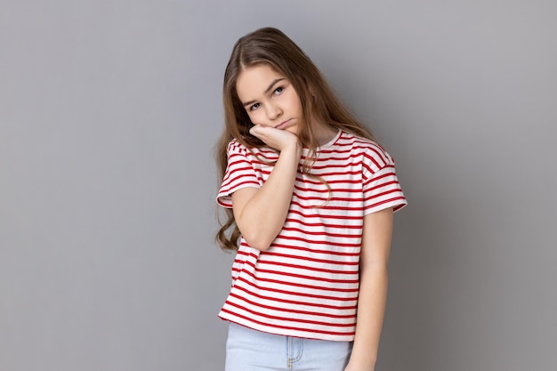 Little girl listening tedious story with gloomy expression being indifferent to conversation