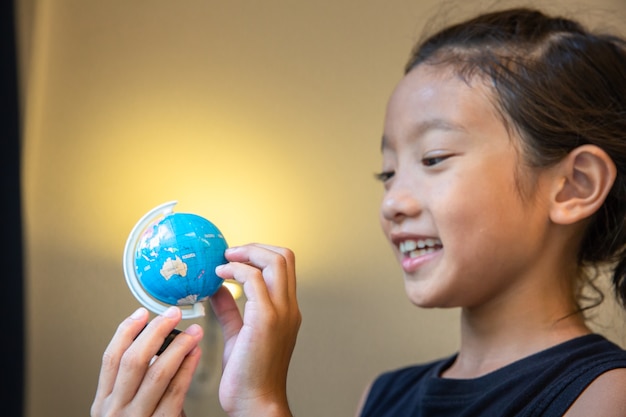 Sguardo della bambina al concetto di ricerca del paese, di istruzione o del viaggio di modello del globo