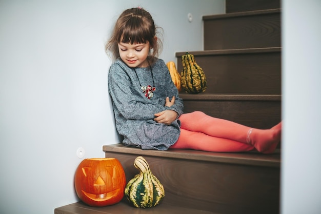 Little girl looking at the Halloween pumpkin