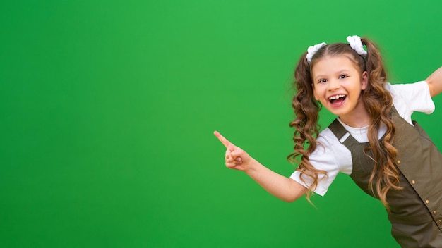 A little girl looks around the corner and smiles A child on an isolated background and copying space