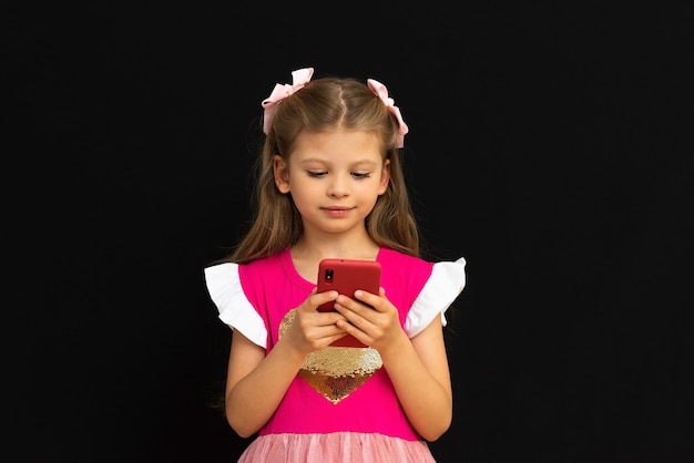 A little girl looks at her phone.