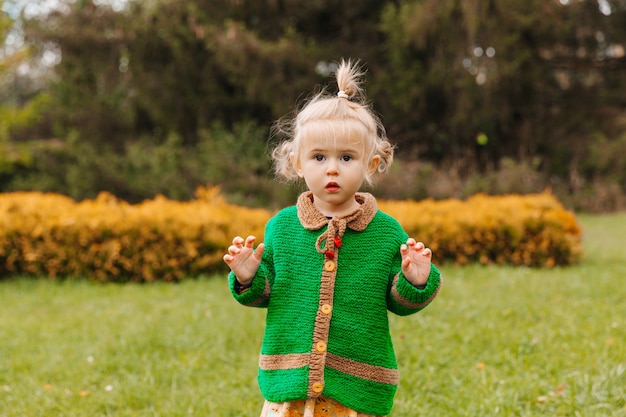 Little girl looks into the camera. serious portrait of a little child on the background of nature.