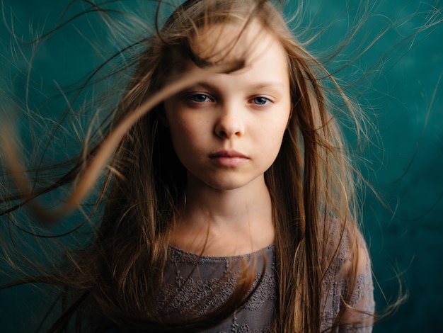 Little girl loose hair green background dissatisfaction\
emotions