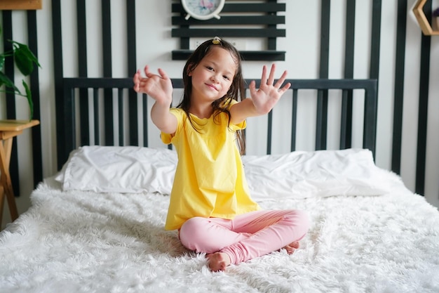 Little girl lying on bed and look at camera