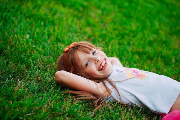 Little girl lying on the grass