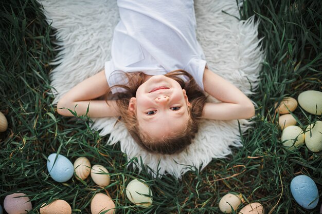 Little girl lying surrounded by Easter eggs