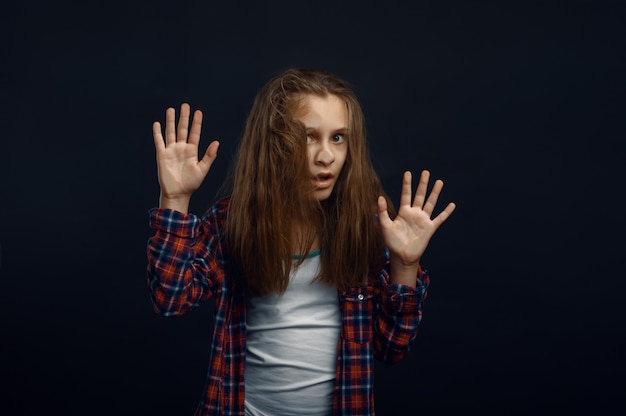 Little girl makes face leaning against the glass