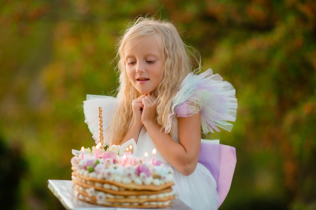 Little girl makes a wish and blows out the candles on the cake