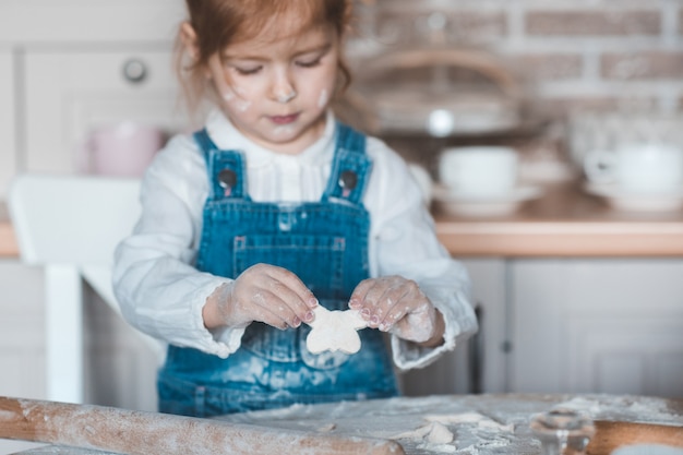 Little girl making cookies wit dough