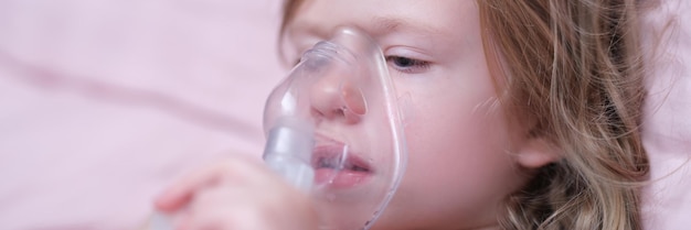 Little girl making inhalation of hormonal drug using nebulizer