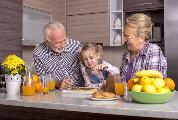 Little girl making pancakes with her grandparents