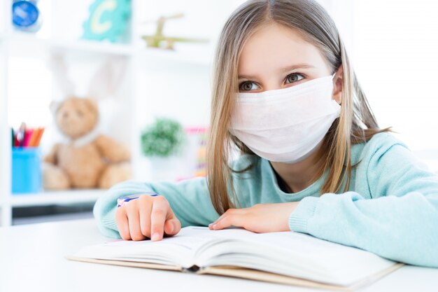 Little girl in mask reading book