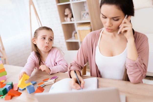 The little girl misses her mother while talking on the phone