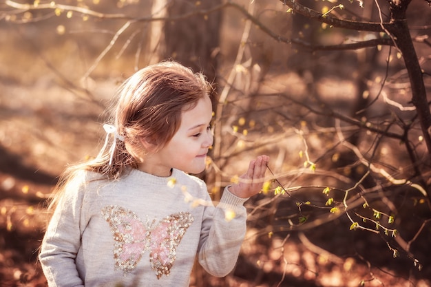 自然の小さな女の子は植物を調べます