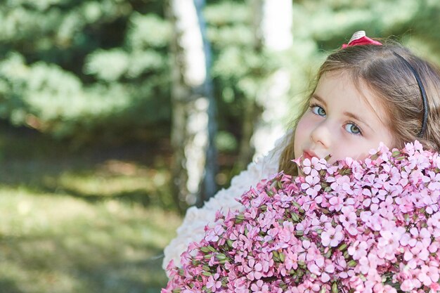 Little girl on nature with flowers