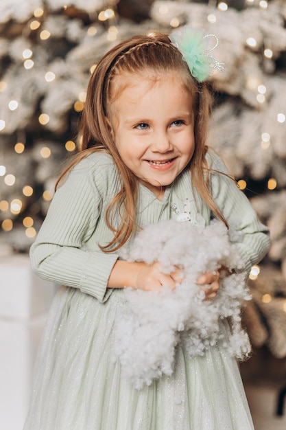 Little girl near Christmas tree. Celebrate New Year