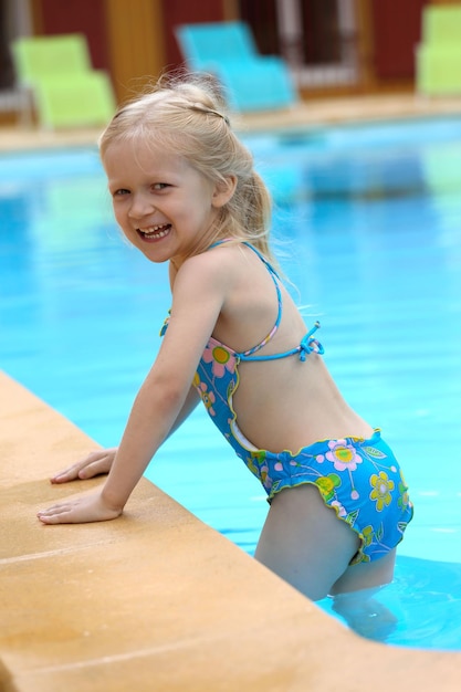 Photo little girl  near the open-air swimming pool