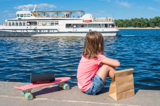 写真 ボートの日当たりの良い夏の日にウォーター フロントの散歩の少女