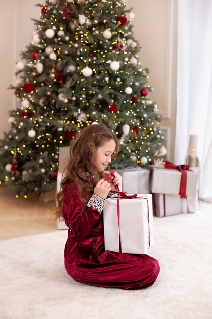 Little girl opening christmas present at home