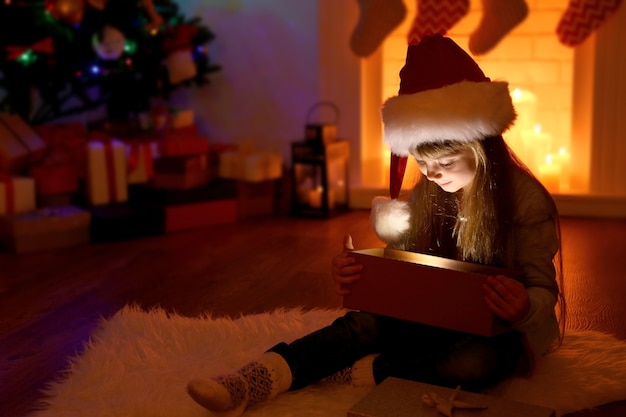 Little girl opening Christmas present in living room