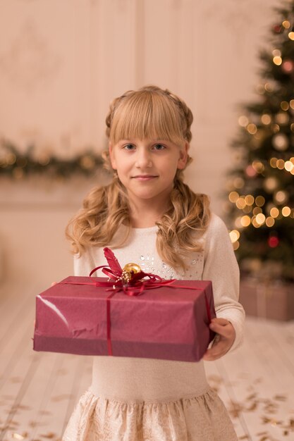 Маленькая девочка открывает рождественский подарок от Санты. Рождественская сказка. Счастливое детство.
