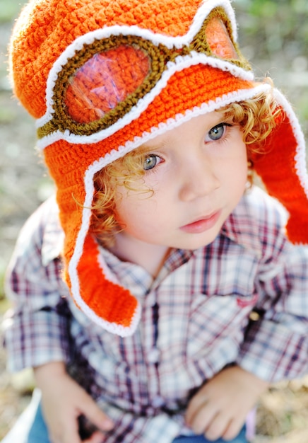 Little girl in the orange cap of the pilot and flight goggles