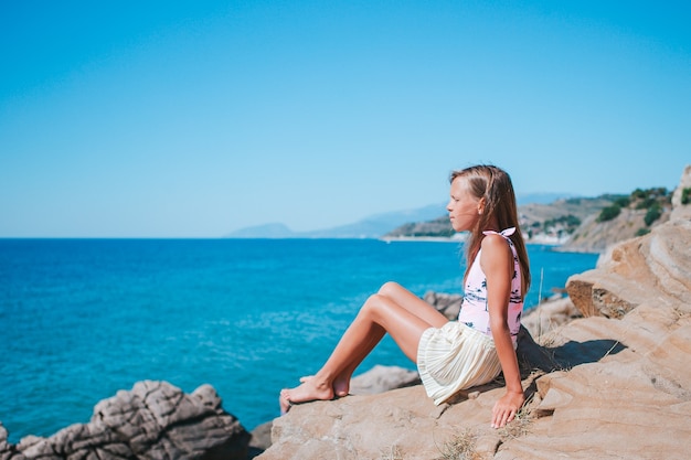 Little girl outdoor on edge of cliff seashore