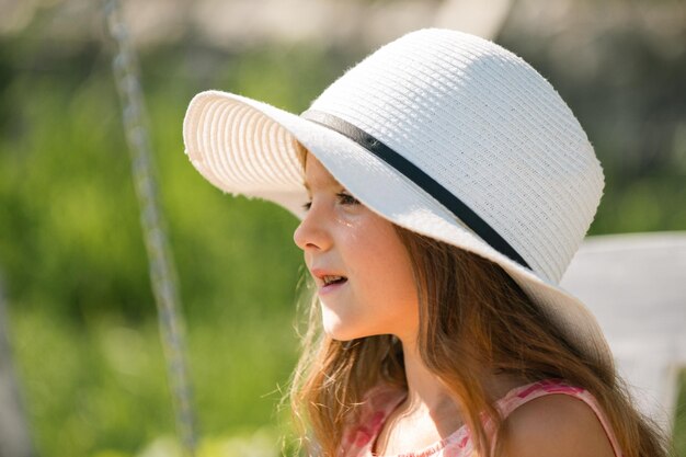 Little girl outdoors closeup Portrait of attractive little teen with beautiful happy smiling face Nature childhood leisure concept Cute child Happy child relax in summer green background