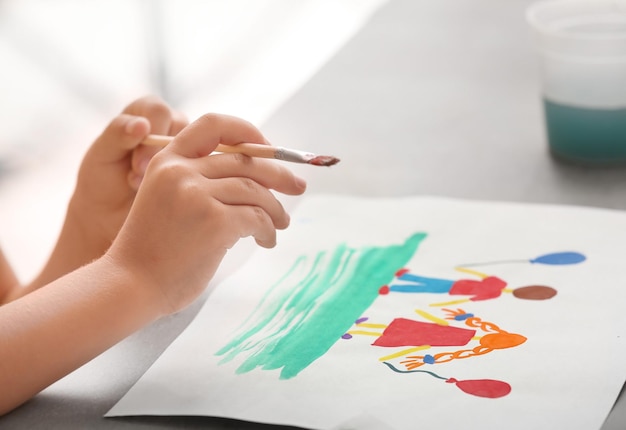Фото Маленькая девочка рисует за столом