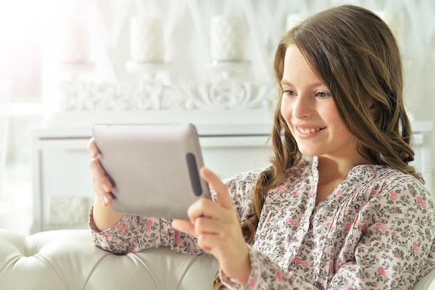 Little girl in pajama using digital tablet